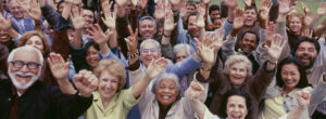 Large group of people cheering with arms raised